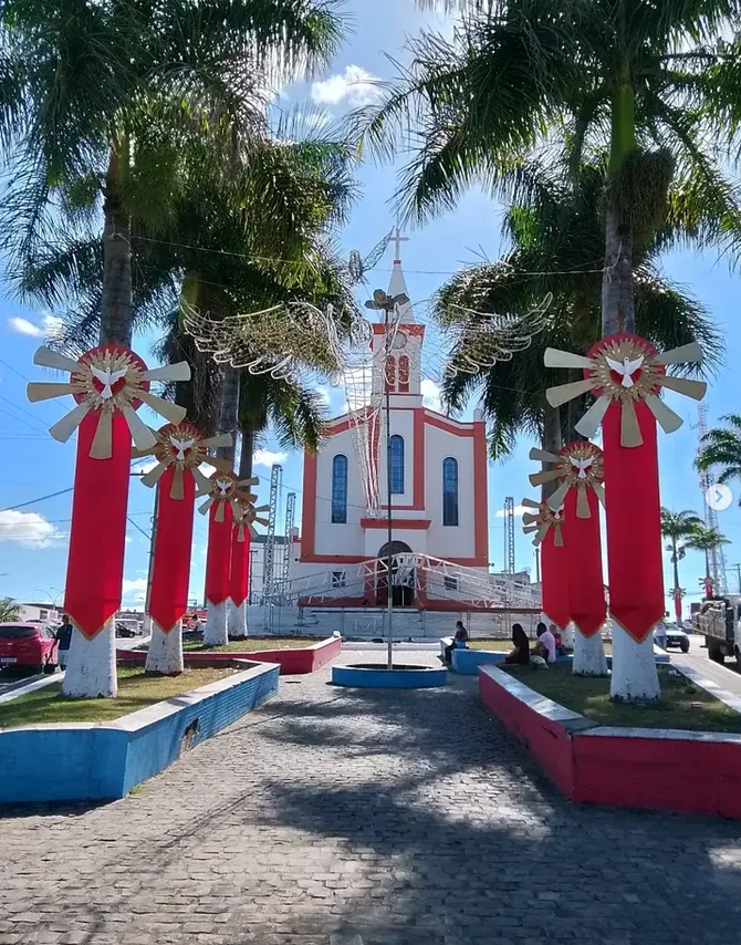 Igreja matriz de Poções, com palmeiras e decoração da festa do Divino
